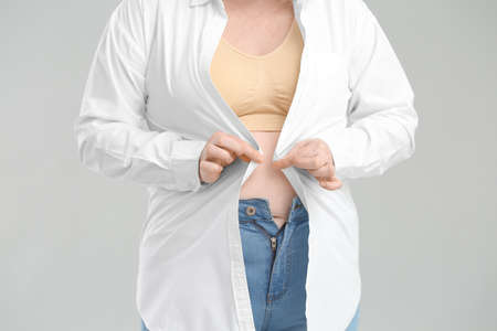 Overweight woman on gray background, closeupの写真素材