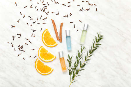 Bottles of roll-on perfume with ingredients on light backgroundの写真素材