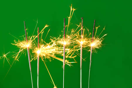 Beautiful Christmas sparklers on color backgroundの写真素材