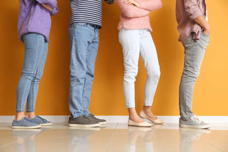 Young people waiting in line near color wallの写真素材