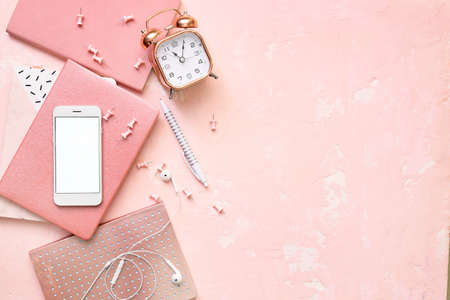 Mobile phone, stationery and alarm clock on color backgroundの写真素材