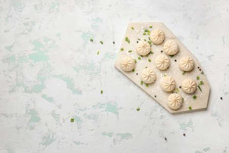 Board with raw dumplings on color backgroundの写真素材