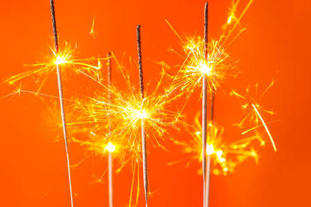 Beautiful Christmas sparklers on color backgroundの写真素材