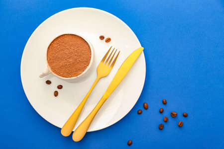 Plate with chocolate cake in shape of coffee cup on color backgroundの写真素材