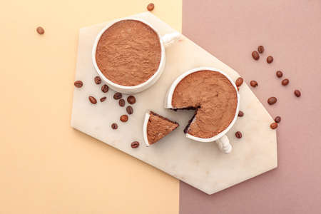 Chocolate cakes in shape of coffee cups on color backgroundの写真素材