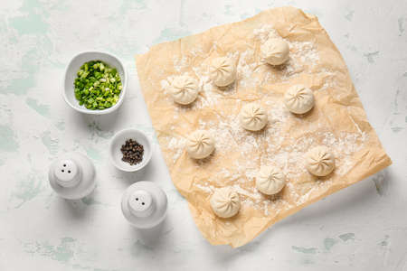 Parchment with raw dumplings on color backgroundの写真素材