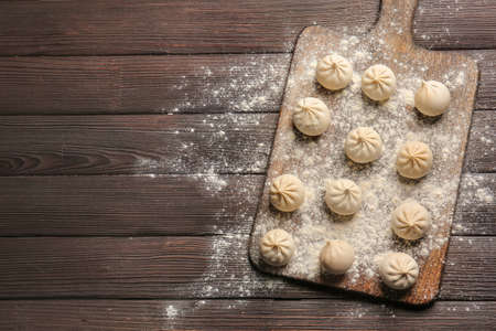 Board with raw dumplings on tableの写真素材