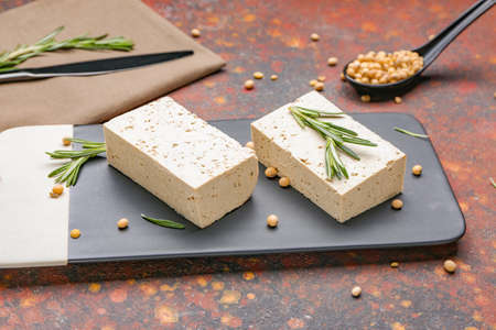 Board with tasty tofu cheese on color backgroundの写真素材