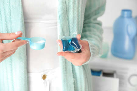 Young woman with washing detergents at home, closeupの写真素材