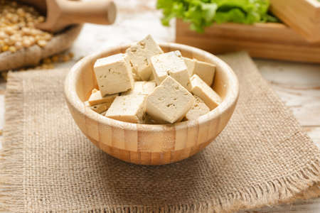 Bowl with tasty tofu cheese on tableの写真素材