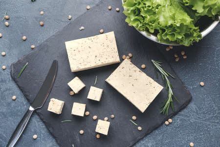 Slate plate with tasty tofu cheese on dark backgroundの写真素材