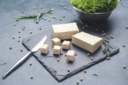 Slate plate with tasty tofu cheese on dark backgroundの写真素材