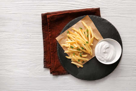 Tasty sour cream and french fries on tableの写真素材