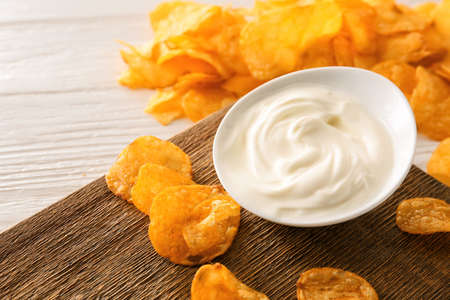 Plate with tasty sour cream and potato chips on tableの写真素材