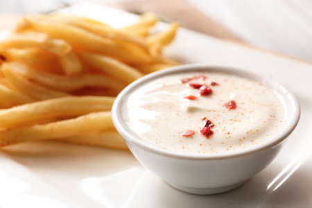 Plate with tasty sour cream and french fries, closeupの写真素材