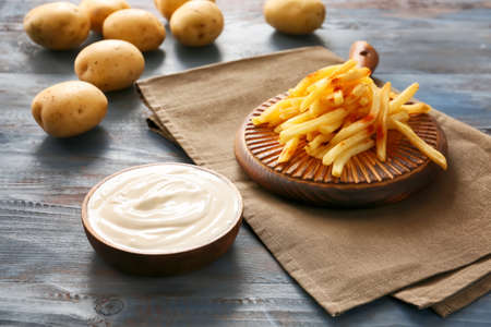 Tasty sour cream and french fries on tableの写真素材