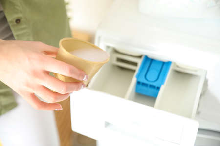 Young woman doing laundry at home, closeupの写真素材