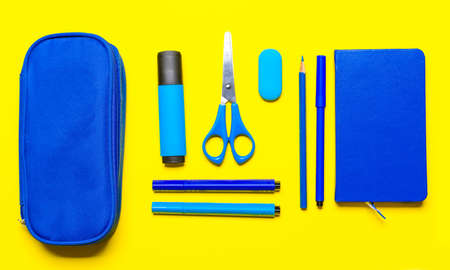 Pencil case and school stationery on color background