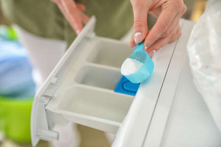 Young woman doing laundry at home, closeupの写真素材