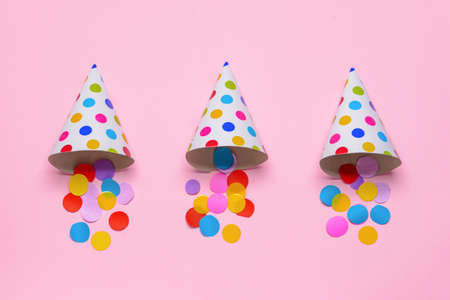 Party hats and confetti on color backgroundの写真素材