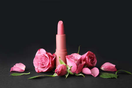 Lipstick and flowers on dark backgroundの写真素材