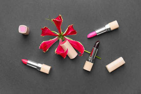 Different lipsticks and flower on dark backgroundの写真素材