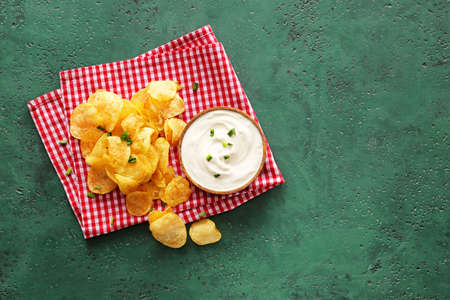 Tasty sour cream and potato chips on tableの写真素材
