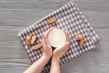 Woman with glass of fresh milk and cookies at table, top viewの写真素材