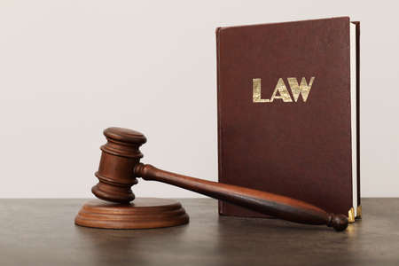 Judge's gavel and book on table against light backgroundの写真素材