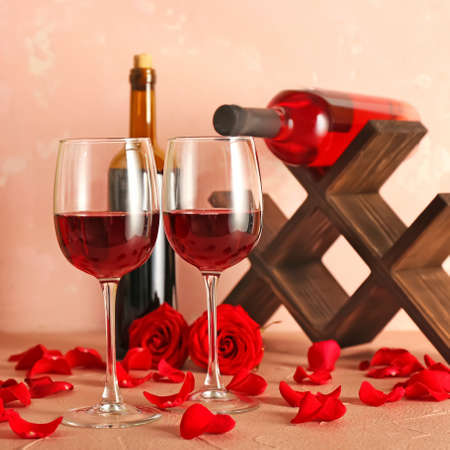 Bottles, glasses of wine and rose petals on tableの写真素材