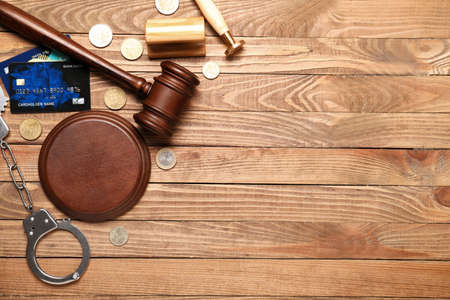 Judge's gavel, credit card, money, stamps and handcuffs on wooden backgroundの写真素材