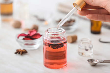 Woman preparing perfume on tableの写真素材