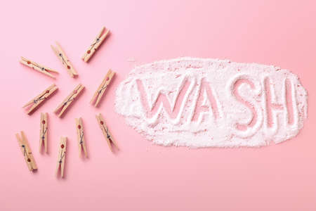 Clothes pegs and word WASH made of laundry detergent on color backgroundの写真素材