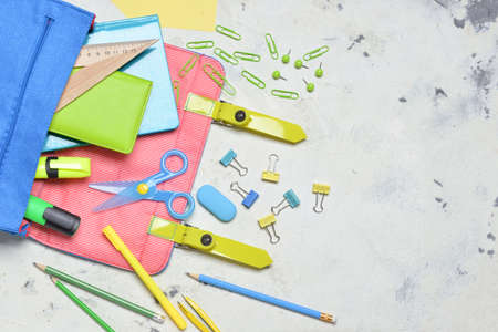 School backpack and stationery on light background