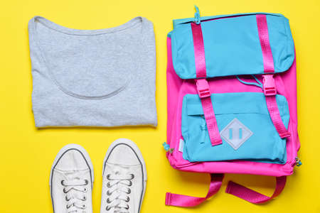 School backpack and clothes on color backgroundの写真素材