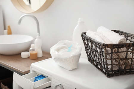 Detergents and clean towels on washing machineの写真素材