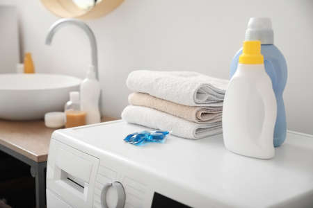 Different detergents and clean towels on washing machineの写真素材