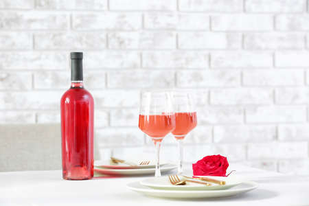 Glasses and bottle of wine on served tableの写真素材