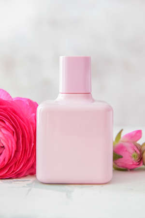 Bottle of perfume with flowers on light backgroundの写真素材