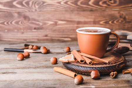 Cup of hot chocolate, cinnamon and cookies on wooden backgroundの写真素材