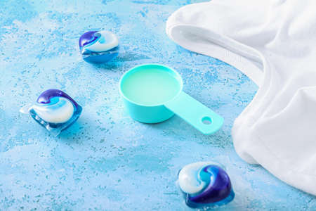 Laundry detergents and clothes on color backgroundの写真素材