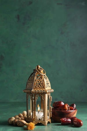 Muslim lamp and tasbih with dates on color backgroundの写真素材