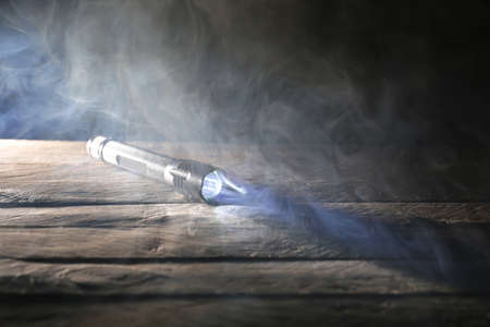 Glowing modern flashlight on wooden tableの写真素材