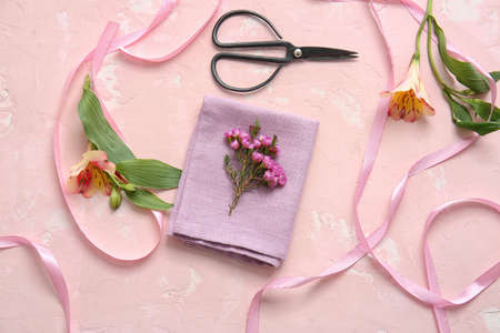 Napkin with floral decor prepared for table setting on color backgroundの写真素材