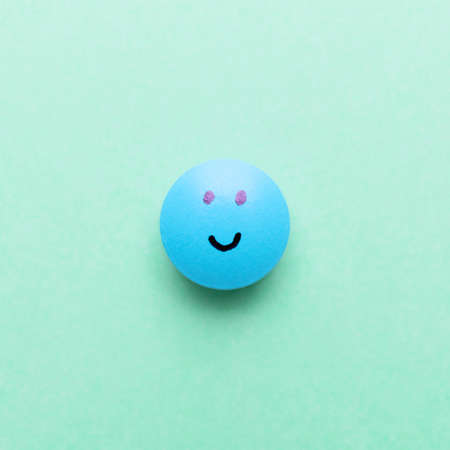 Pill with drawn face on color backgroundの写真素材