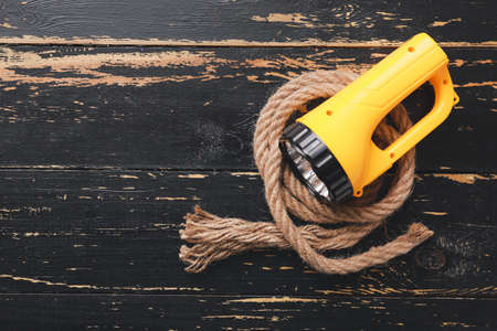 Modern flashlight with rope on dark wooden backgroundの写真素材