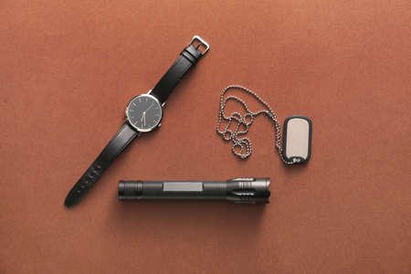 Modern flashlight with tag and watch on color backgroundの写真素材