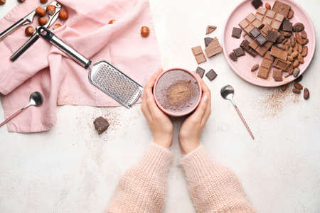 Female hands with cup of hot chocolate on white backgroundの写真素材