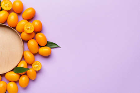 Tasty kumquat fruit with plate on color backgroundの写真素材