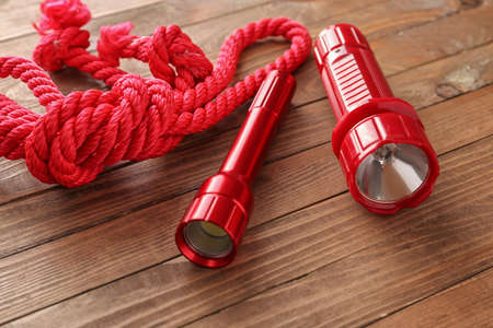 Modern flashlights with rope on wooden backgroundの写真素材